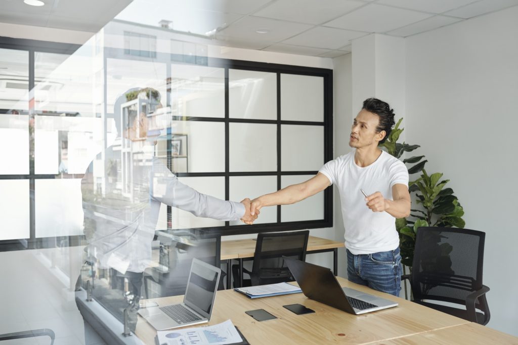 Project manager shaking hand of coworker